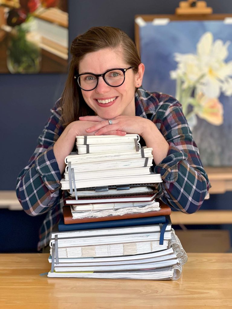 Jill with a stack of sketchbooks