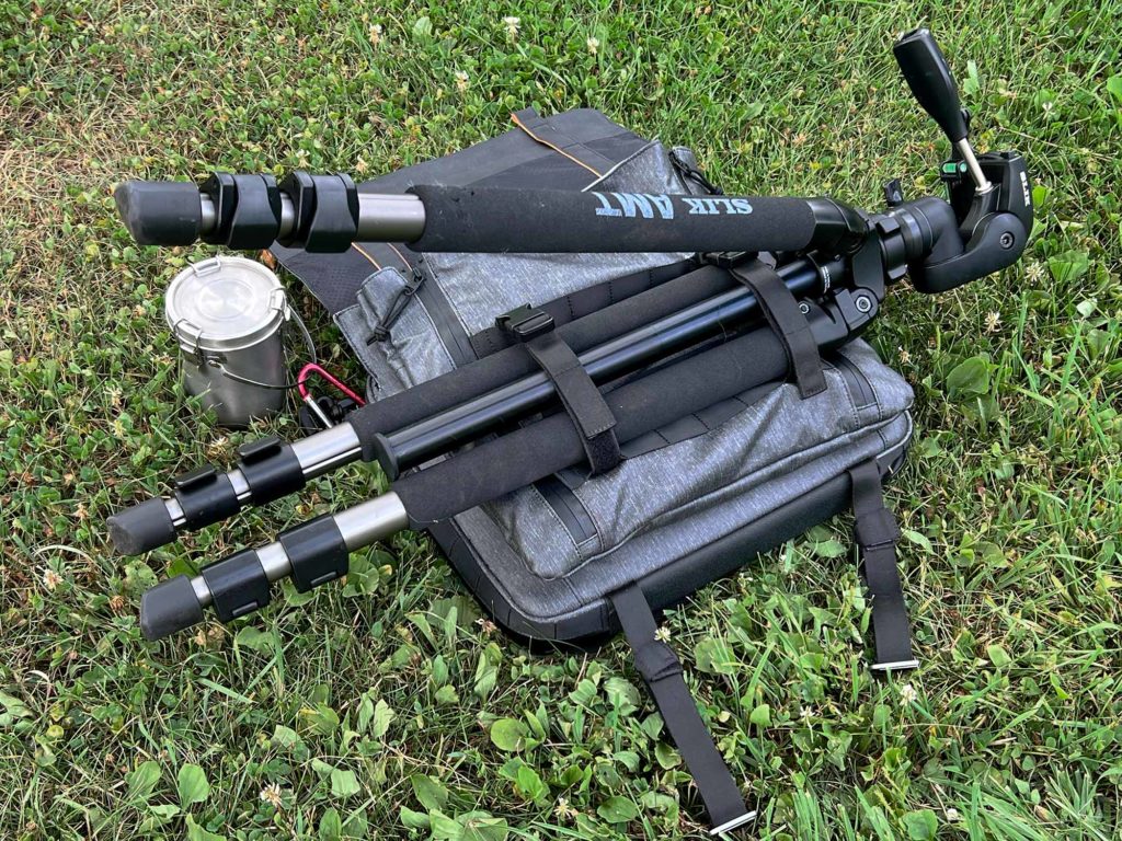 A large tripod attached to the satchel via straps.