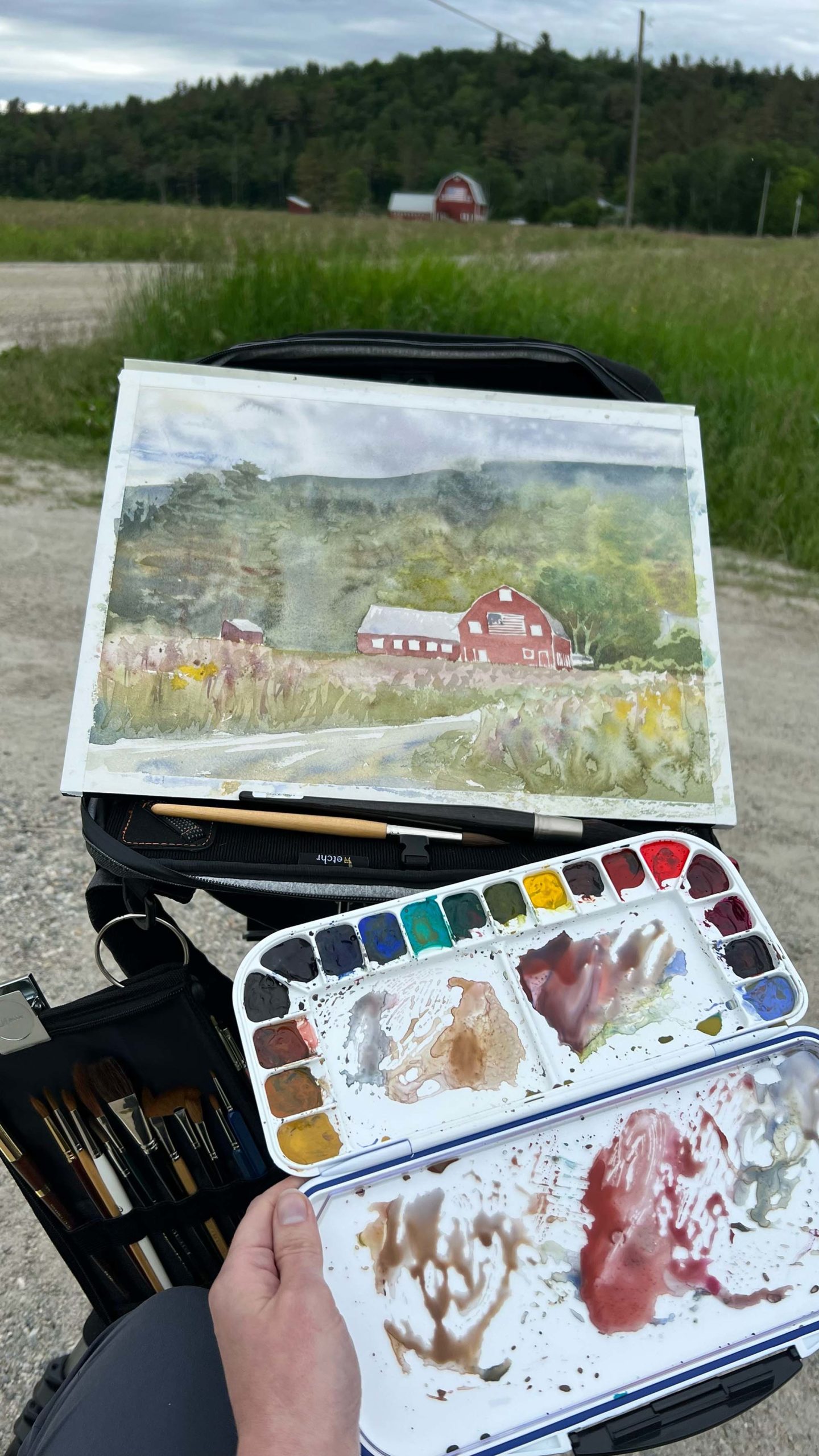 A landscape painting of a barn in progress.